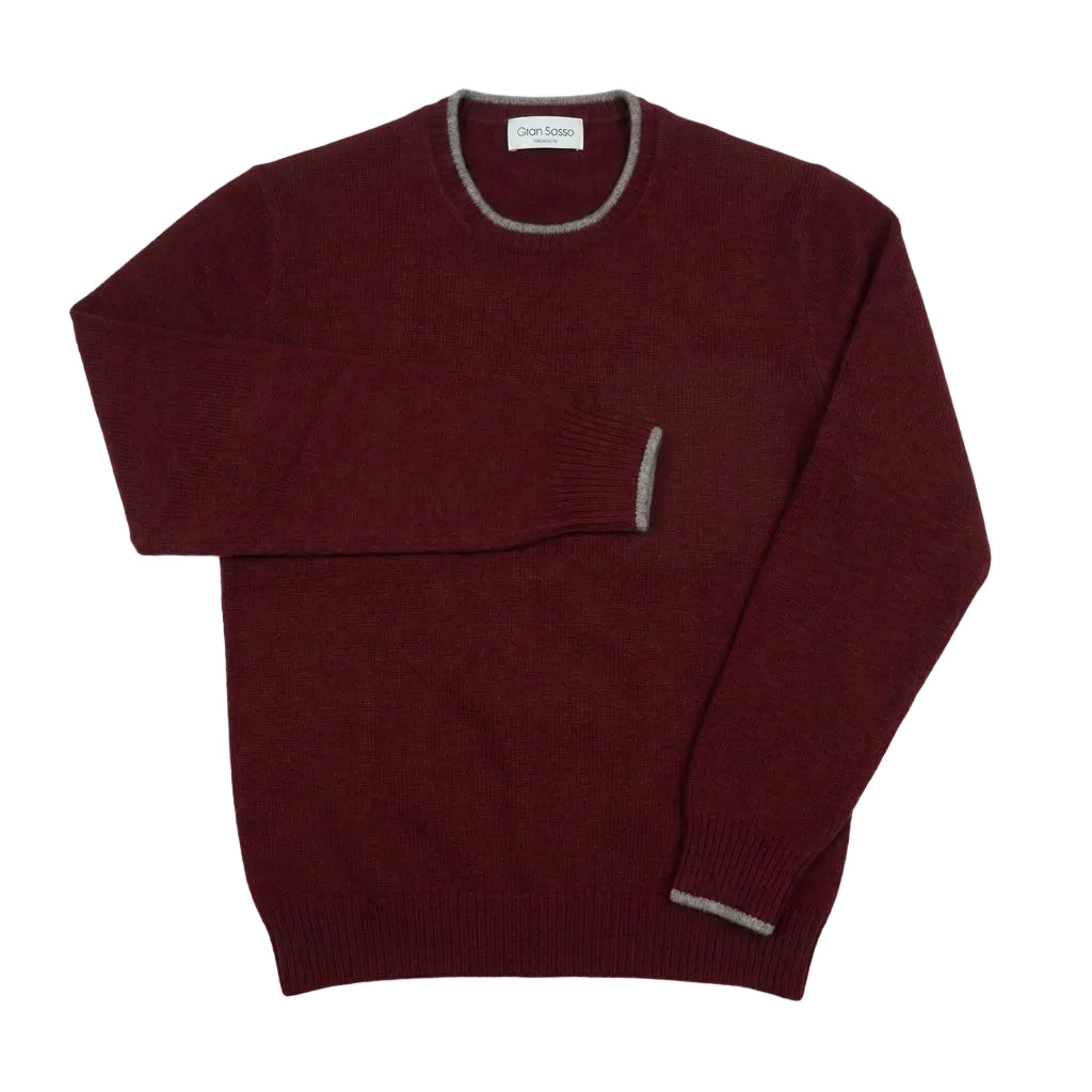 A maroon knit crewneck sweater with gray ribbed trim on the collar, sleeve cuffs, and hem, laid flat on a light gray background.