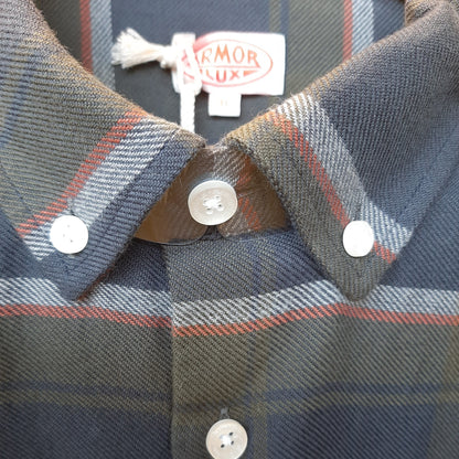 Close-up of a plaid button-down shirt collar with white buttons and a visible interior neck label reading ARMOR LUXE.