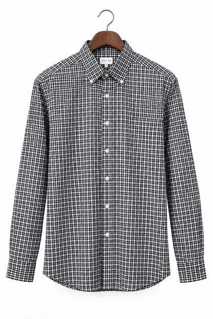 A long-sleeve button-down shirt with a black and white micro-check pattern, hanging on a wooden hanger against a plain white background.