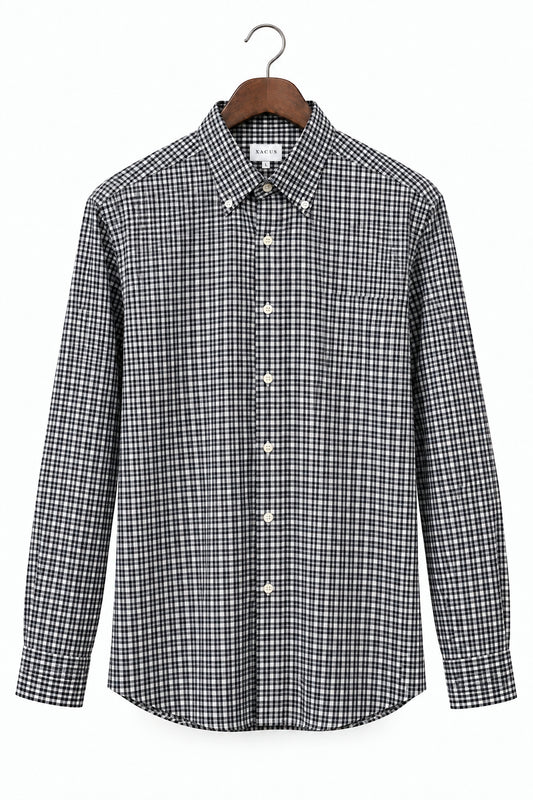 A long-sleeve button-down shirt with a black and white micro-check pattern, hanging on a wooden hanger against a plain white background.