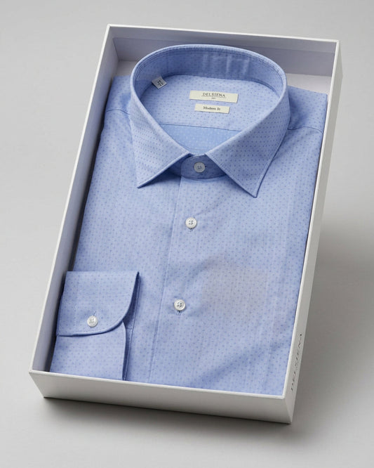 A light blue micro-patterned dress shirt folded inside a white presentation box, photographed on a clean light gray background.